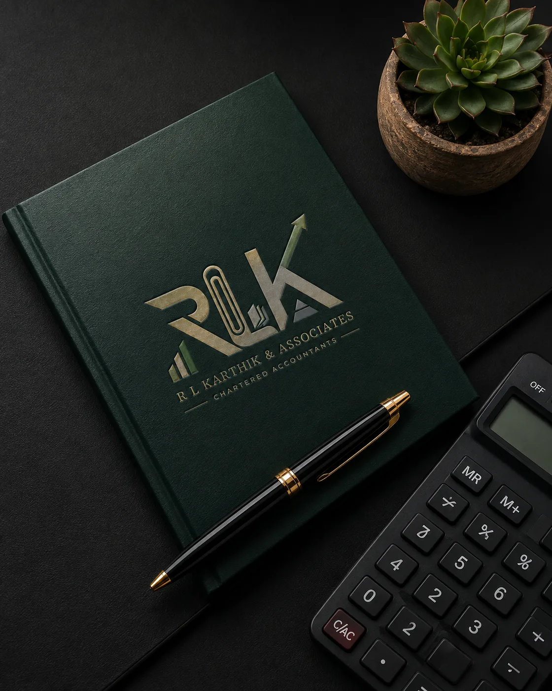 R L Karthik & Associates branded notebook, pen and calculator on a desk